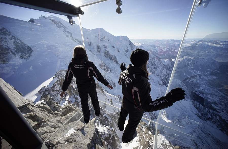 Employees stand in the 'Step into the Void' installation at the Aiguille du Midi mountain peak above Chamonix, in the French Alps